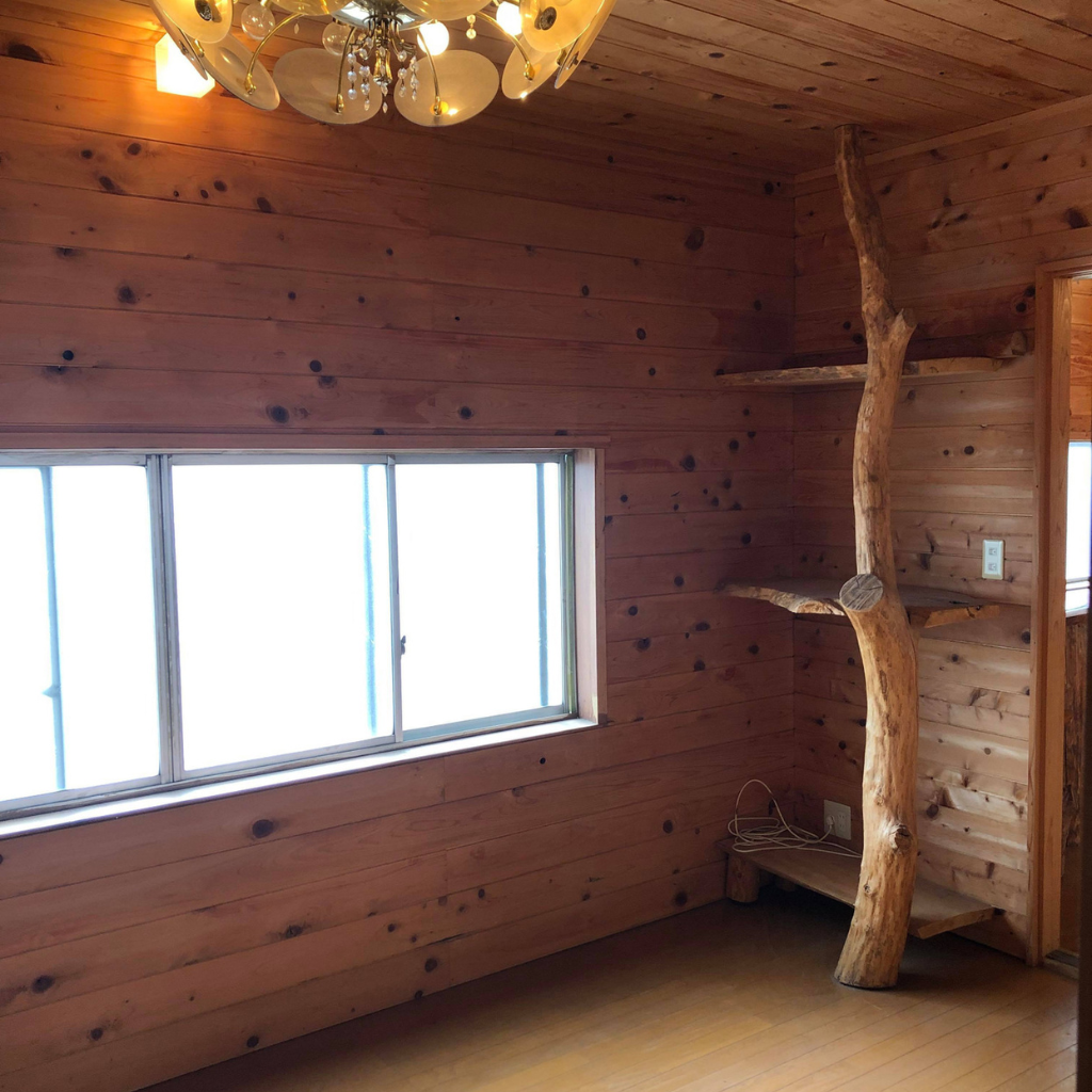 木造建築の一室に照明と木造のオブジェがある様子（1,024pxの正方形）