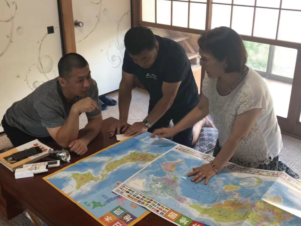 日本地図を見る3人の男女